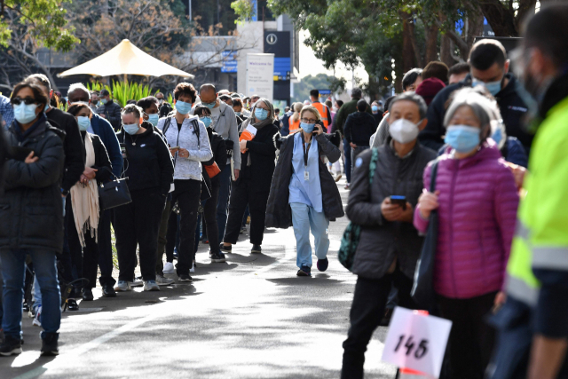 호주 뉴사우스웨일스(NSW)주가 신종 코로나바이러스 감염증(코로나19) 델타 변이 확산으로 비상인 가운데 7일(현지시간) 시드니 외곽 홈부시에 마련된 코로나19 백신 접종소 앞에 백신을 맞으려는 주민들이 장사진을 이루고 있다. NSW주 정부는 전날 비상내각회의를 열고 당초 오는 9일 해제 예정이었던 광역 시드니의 코로나19 봉쇄령을 16일까지 한 주 더 연장하기로 했다. 연합뉴스