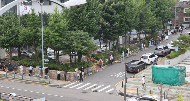신종 코로나바이러스 감염증(코로나19) 확진자 수가 사흘째 1천 명을 넘고 있는 가운데 11일 오후 서울 강서구보건소 선별진료소에서 검사를 받기 위해 시민들이 줄을 서 있다. 연합뉴스