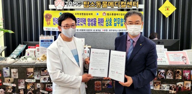 박순석(왼쪽) 탑스동물메디컬센터 원장과 서병부 대구대 과학생명융합대학장이 협약서를 들어보이고 있다. 대구대 제공