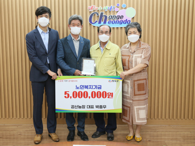 박종우 강산농장 대표(왼쪽 두번째)가 청도군을 방문해 노인복지기금을 전달하고 있다. 청도군 제공