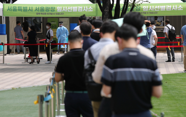 폭염특보가 내려진 14일 서울광장 임시선별검사소에서 시민들이 검사를 기다리고 있다. 중앙방역대책본부는 이날 0시 기준 신규 확진자가 전날보다 465명 늘어난 1천615명이라고 밝혔다. 연합뉴스