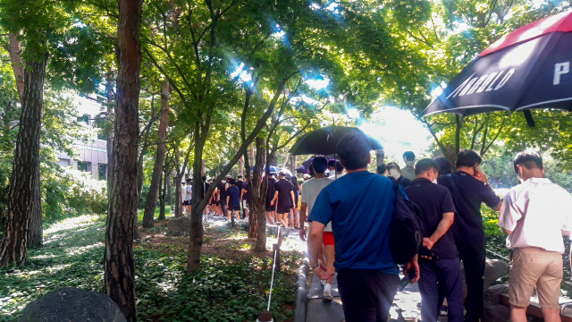 15일 정오쯤 찾은 대구 중구 국채보상공원 코로나19 임시선별검사소. 검사자들이 햇빛을 피하려 우산과 양산을 쓰고 기다리고 있다. 윤정훈 기자