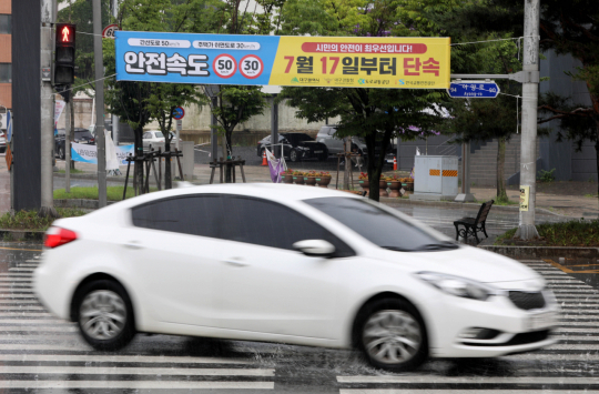 15일 오후 대구 동구 파티마삼거리에 걸린 안전속도 5030 단속 예고 현수막 아래로 시민들이 횡단보도를 건너고 있다. 김영진 기자 kyjmaeil@imaeil.com