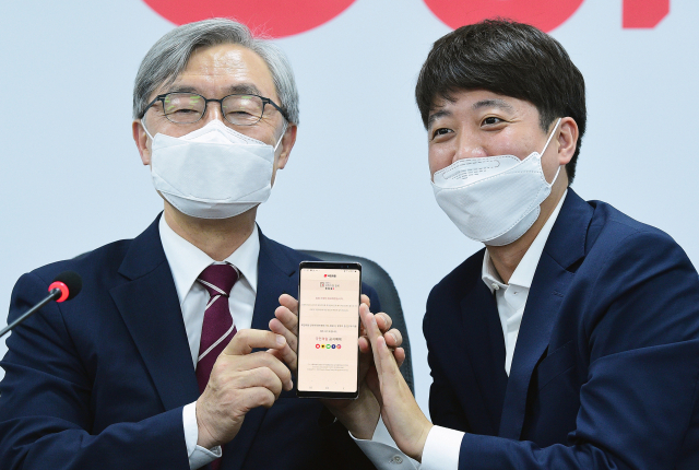 최재형 전 감사원장이 15일 서울 여의도 국민의힘 당사에서 이준석 대표의 도움을 받아 모바일 입당원서를 작성한 뒤 들어보이고 있다. 연합뉴스