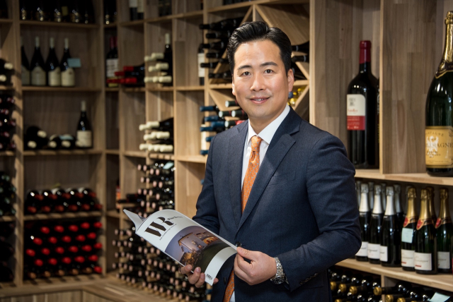 DK VINO 김동국 대표가 지역 중견 화가 윤종주 컬래버 작품 전시회에 대해 설명하고 있다.