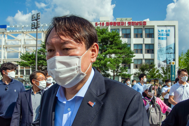 대선 출마를 선언한 윤석열 전 검찰총장이 17일 오후 5·18민주화운동 역사현장인 광주 동구 옛 전남도청 별관 방문을 마친 뒤 자동차로 이동하고 있다. 윤 전 총장 왼쪽 가슴에 5·18 상징 장식이 달려있다. 연합뉴스