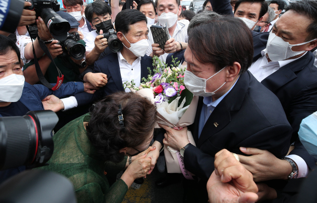 윤석열 전 검찰총장이 20일 오후 대구 중구 서문시장을 찾아 한 상인에게 꽃다발을 받고 있다. 김영진 기자 kyjmaeil@imaeil.com