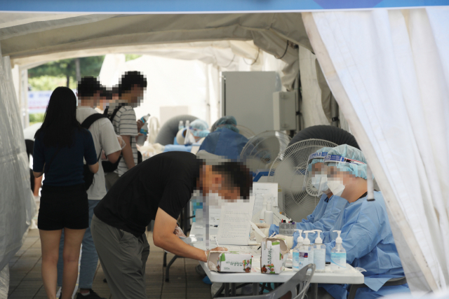 22일 오후 서울 낙성대공원 임시선별검사소에서 시민들이 신종 코로나바이러스 감염증(코로나19) 검사를 받기 위해 대기하고 있다. 관악구 사우나 집단감염 확진자는 모두 143명으로 늘었다. 연합뉴스
