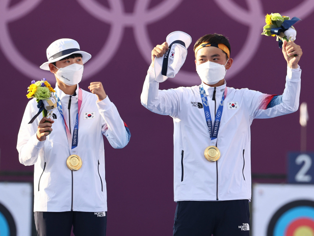 양궁 국가대표 김제덕과 안산이 24일 일본 도쿄 유메노시마 공원 양궁장에서 열린 도쿄 올림픽 혼성 단체전에서 금메달을 획득한 뒤 환호하고 있다. 연합뉴스