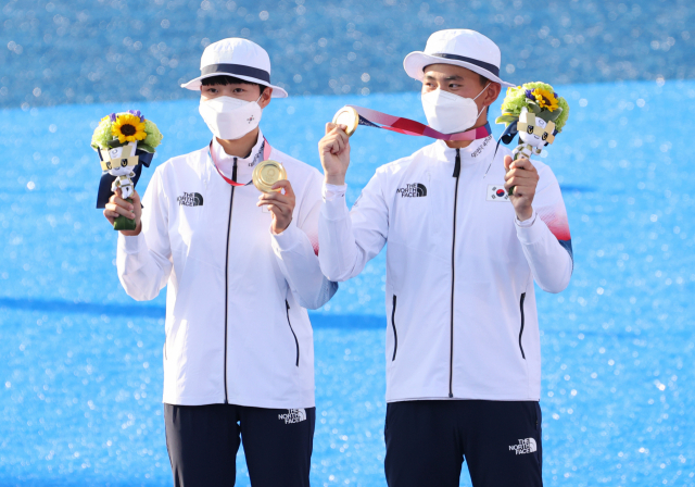 24일 일본 도쿄 유메노시마 공원 양궁장에서 열린 도쿄올림픽 혼성 결승전에서 금메달을 획득한 양궁 국가대표 김제덕과 안산이 포즈를 취하고 있다. 연합뉴스