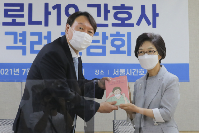 야권 대선주자인 윤석열 전 검찰총장이 22일 서울시 구로구 서울시간호사회를 방문, 박인숙 회장으로부터 대한간호협회가 출간한 도서 