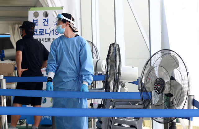 26일 오전 서울시 동대문구 전농동 청량리역 광장에 마련된 임시선별검사소에서 의료진과 대기자의 열기를 식혀줄 선풍기가 쉼 없이 돌아가고 있다. 연합뉴스