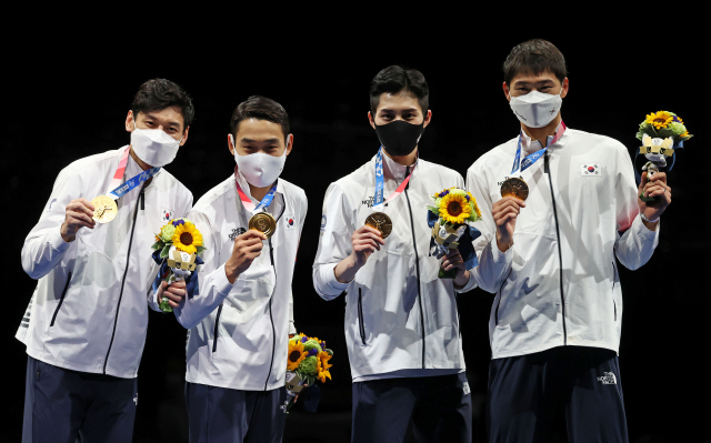 28일 일본 지바의 마쿠하리 메세에서 열린 도쿄올림픽 남자 펜싱 사브르 단체전 시상식에서 대한민국 선수들이 금메달을 들어 보이고 있다. 왼쪽부터 구본길, 김정환, 김준호, 오상욱. 연합뉴스