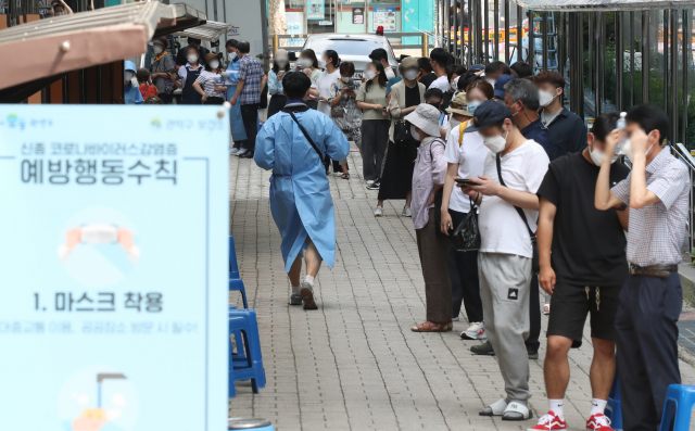 국내 신종 코로나바이러스 감염증(코로나19) 확산세가 갈수록 거세지며 신규 확진자 수가 1천896명을 기록, 6일 만에 또다시 최다 기록을 경신한 28일 서울 관악구 보건소 선별진료소에서 시민들이 코로나19 검사를 위해 길게 줄지어 서 있다. 연합뉴스