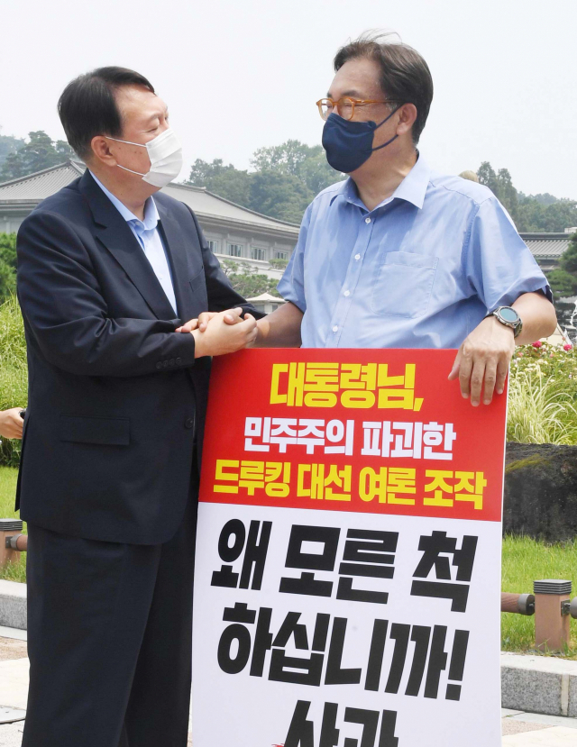 윤석열 대선 예비후보가 29일 오전 서울 종로구 청와대 앞 분수대 광장에서 드루킹 댓글 조작 사건과 관련 문재인 대통령의 사과를 촉구하며 1인 시위를 하는 국민의힘 정진석 의원을 지지 방문해 인사하고 있다. 연합뉴스