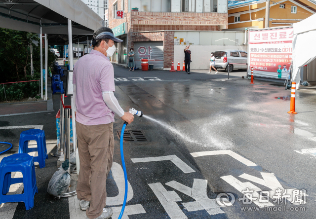 29일 오전 불볕더위 속에 대구 수성구보건소 선별진료소에서 보건소 관계자가 열기를 식히기 위해 물을 뿌리고 있다. 우태욱 기자 woo@imaeil.com