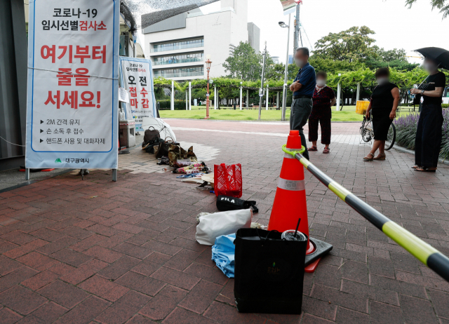 28일 대구국채보상운동기념공원 코로나19 임시선별검사소에서 오후 검사소 운영 시작에 앞서 대기 순서를 표시하기 위한 시민들의 소지품들이 바닥에 놓여져 있다. 우태욱 기자 woo@imaeil.com