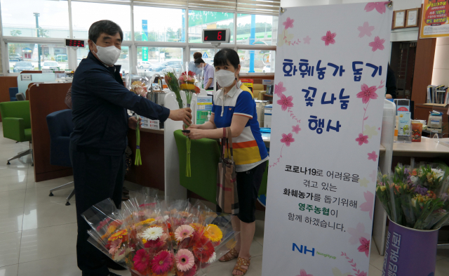 남정순 조합장이 파머스마켓 방문한 고객에게 꽃 다발을 전달하고 있다. 영주농협 제공