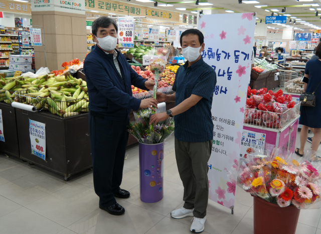 남정순 조합장이 파머스마켓 방문한 고객에게 꽃 다발을 전달하고 있다. 영주농협 제공