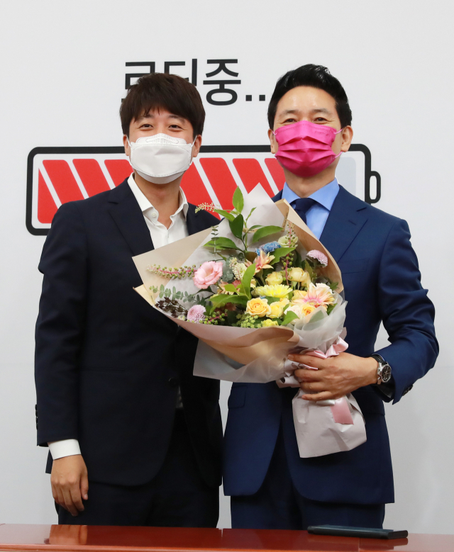 국민의힘 이준석 대표(왼쪽)가 2일 오전 서울 여의도 국회에서 열린 장성민 전 의원 입당 환영식에서 장 전 의원에게 입당 축하 꽃다발을 전달하고 기념촬영하고 있다. 장 전 의원은 김대중 정부 시절 국정상황실장 등을 맡았다. 연합뉴스
