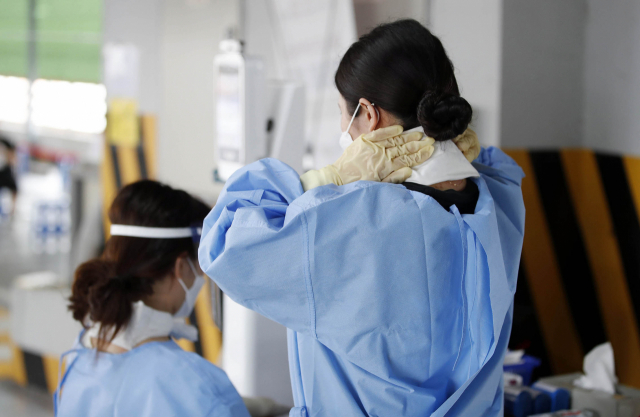 전국 대부분 지역에 폭염 특보가 내려진 2일 오전 광주 북구 선별진료소에서 보건소 의료진들이 거즈에 아이스팩을 넣어 만든 냉 목도리를 걸치고 업무를 하고 있다. 연합뉴스