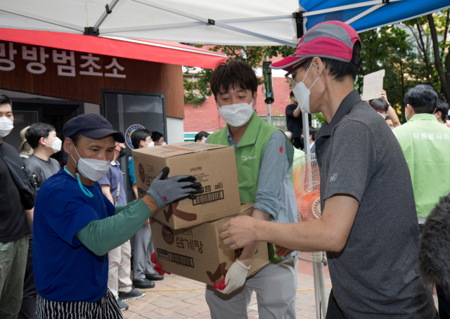 국민의힘 이준석 대표와 대선 경선 예비후보자들이 4일 오전 서울 용산구 동자동 쪽방촌을 찾아 삼계탕과 물을 혹서기 취약계층에게 나눠주는 자원봉사행사를 가졌다. 이준석 대표가 삼계탕 박스를 나르고 있다. 연합뉴스