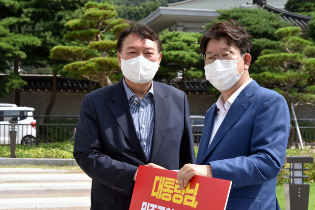 국민의힘 윤석열 대선 예비후보가 4일 오전 청와대 앞 분수대 앞에서 드루킹 대선 여론조작에 대한 문재인 대통령의 사과 촉구 1인시위를 하는 국민의힘 권성동 의원을 방문해 대화하고 있다. 연합뉴스