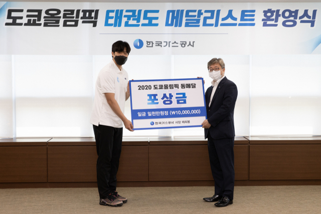 채희봉(오른쪽) 가스공사 사장이 인교돈 선수에게 포상금을 지급하고 있다. 가스공사 제공