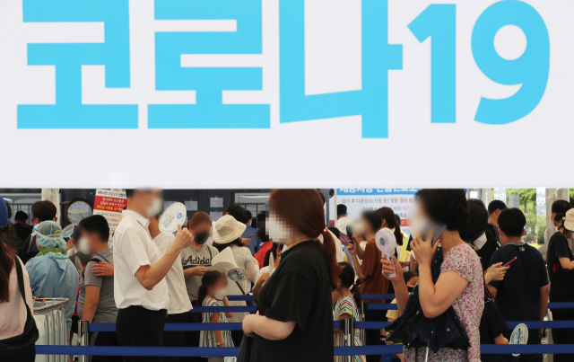 신종 코로나바이러스 감염증(코로나19)의 비수도권 확산세가 무섭게 이어지고 있는 가운데 5일 오후 세종시 세종시청에 마련된 선별진료소에 검사를 받으려는 시민들이 부채로 더위를 식히며 순서를 기다리고 있다. 연합뉴스