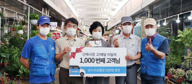지난 7월 신매시장 GO배달 서비스의 1,000번째 고객이 된 주민이 온누리상품권 10만 원을 전달받고 기념촬영 하고 있다.