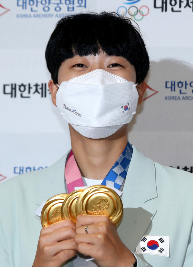 2020 도쿄올림픽 양궁 3관왕 안산이 1일 오후 영종도 인천국제공항을 통해 귀국한 뒤 금메달을 들어보이며 밝게 웃고 있다. 연합뉴스