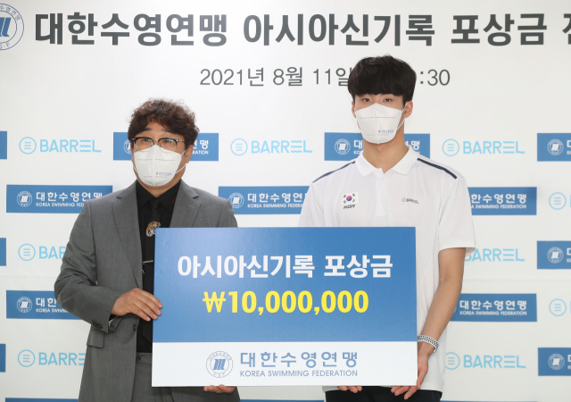 황선우(오른쪽)가 11일 서울 대한체육회 회의실에서 열린 대한수영연맹 아시아신기록 포상금 전달식에서 정창훈 연맹 회장으로부터 포상금 1천만 원을 전달받고 있다. 연합뉴스