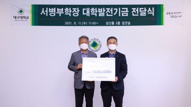 서병부(오른쪽) 대구대 과학생명융합대학장이 최근 김상호 총장을 찾아 발전기금 1천만원을 전달한 뒤 기념촬영을 하고 있다. 대구대 제공
