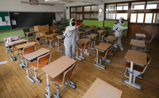 2학기 개학을 앞둔 12일 대구 수성구 동도중학교 교실에서 대구학교안전공제회 관계자들이 방역 작업을 하고 있다. 김영진 기자 kyjmaeil@imaeil.com
