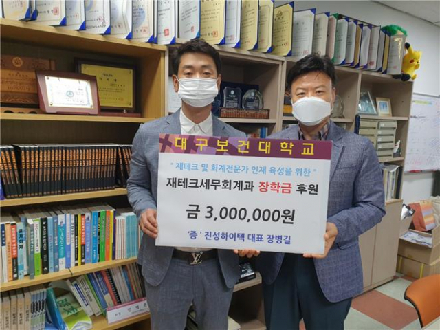 장병길 진성하이텍 대표(왼쪽)가 성백춘 대구보건대 세무회계과 학과장에게 장학금을 전달한 뒤 기념촬영을 하고 있다. 대구보건대 제공