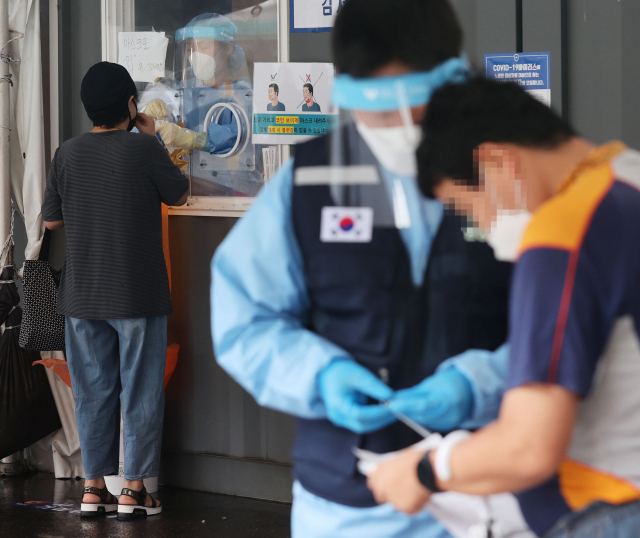 18일 국내 신종 코로나바이러스 감염증(코로나19) 신규 확진자 수가 다시 1800명대 초반까지 치솟았다. 신규 확진자는 지난달 7일(1212명)부터 43일 연속 네 자릿수를 이어갔다. 중앙방역대책본부(방대본)는 이날 0시 기준 신규 확진자가 1805명 늘어 누적 22만8657명이라고 밝혔다. 18일 오전 서울역 앞에 마련된 중구 임시선별검사소 앞에서 시민들이 검사를 받고 있다. 연합뉴스