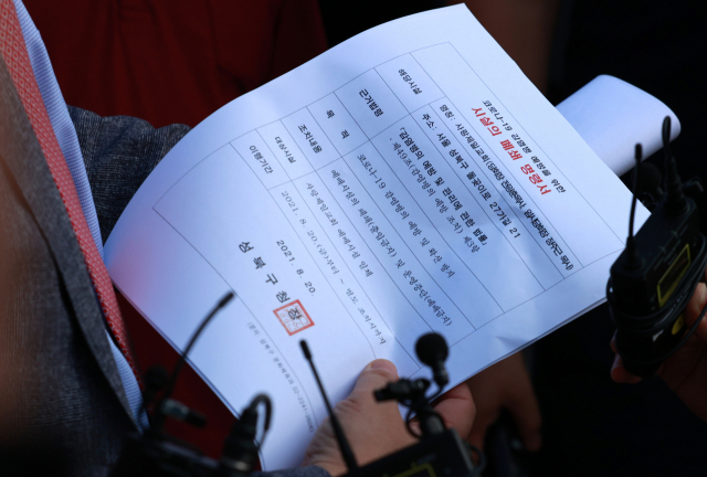 사랑제일교회 측 이성희 변호사가 19일 오후 서울 성북구 사랑제일교회 앞에서 성북구청 문화체육과로부터 수령한 시설 폐쇄 명령서를 들고 있다. 서울 성북구는 이날 신종 코로나바이러스 감염증 방역수칙 위반과 운영중단명령 위반을 이유로 사랑제일교회에 대한 시설폐쇄를 결정했다. 연합뉴스