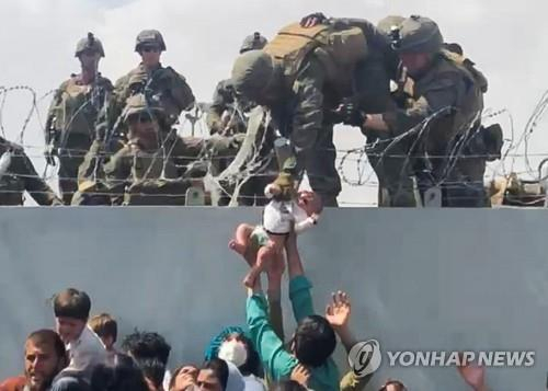 카불공항에서 미군이 아프간인의 간절한 요청에 아기만 구조하는 모습. 연합뉴스