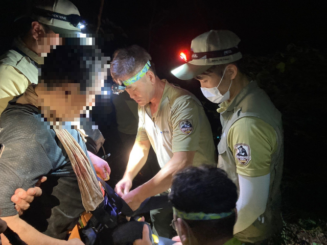 지난 22일 오후 3시 18분쯤 경북 청송군 부동면 주왕산 주봉 인근에서 실종된 60대 남성을 관계 당국이 발견해 이송을 하기 전 응급처치를 하고 있다. 안동소방서 제공