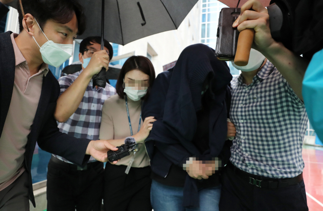 23일 오후 자신이 출산한 아기를 음식물 쓰레기통에 유기한 A씨가 구속 전 피의자 심문(영장실질심사)을 마치고 청주지방법원을 나서고 있다. 연합뉴스