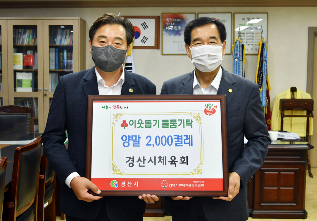 경산시체육회 강영근(왼쪽) 회장이 24일 코로나19 현장 의료진을 위해 양말 2천켤레를 기탁했다.