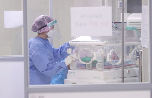 경기도 고양시 국민건강보험 일산병원에서 코로나19 확진 환자 제왕절개 수술이 끝난 뒤 간호사가 신생아를 인큐베이터를 이용해 음압격리병실로 옮기고 있다. 연합뉴스