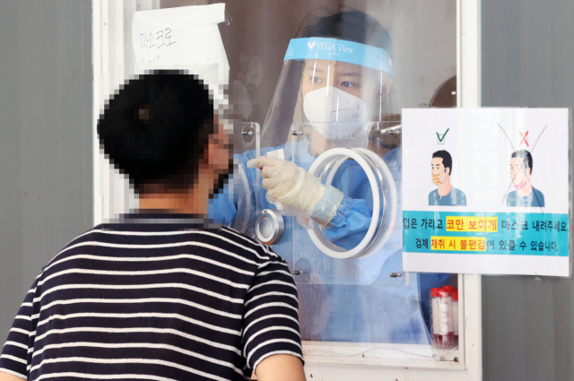 30일 서울역 광장에 마련된 신종 코로나바이러스 감염증(코로나19) 임시선별검사소에서 의료진이 검체를 채취하고 있다. 연합뉴스