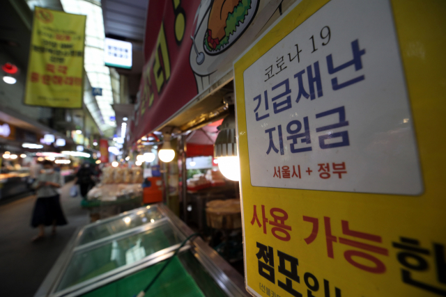 대표적 서민 음식인 치킨 가격이 줄줄이 인상될 전망이다. 교촌치킨에 이어 bhc치킨도 제품 가격을 인상키로 했다. 사진은 30일 서울의 한 시장 내 가게에 붙은 긴급재난지원금 사용 가능 안내 문구. 연합뉴스