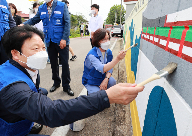 이병환 성주군수와 이인선(오른쪽) 계명대 대구경북사회혁신지원단장이 월항면 백인마을 벽화그리기 자원봉사에 동참하고 있다. 성주군 제공