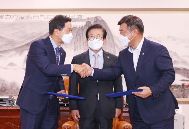 더불어민주당 윤호중 원내대표(오른쪽)와 국민의힘 김기현 원내대표가 31일 서울 여의도 국회 의장실에서 언론중재법 개정안을 위한 협의체 구성, 9월 27일 본회의 상정 등의 합의문을 교환하고 있다. 가운데는 박병석 국회의장. 연합뉴스