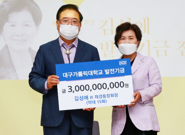 김성애(오른쪽) 전 대구가톨릭대 재경동창회장이 31일 모교에 발전기금 30억원을 기부한 뒤 우동기 총장과 피켓을 들어 보이고 있다. 대구가톨릭대 제공