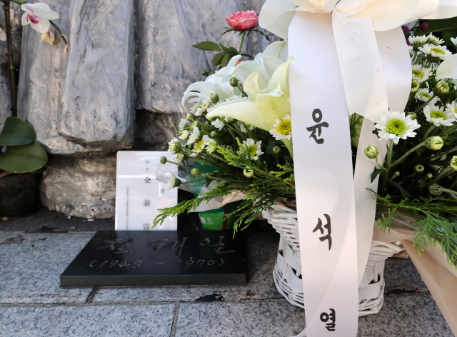 3일 서울 종로구 청계천 버들다리(전태일다리) 내 전태일 열사 동상 앞에 국민의힘 윤석열 대선 경선 후보의 이름이 적힌 화환이 놓여 있다. 이날 윤 후보는 전태일 열사의 어머니 고 이소선 여사 10주기를 맞아 전태일 열사 동상을 방문했다. 연합뉴스