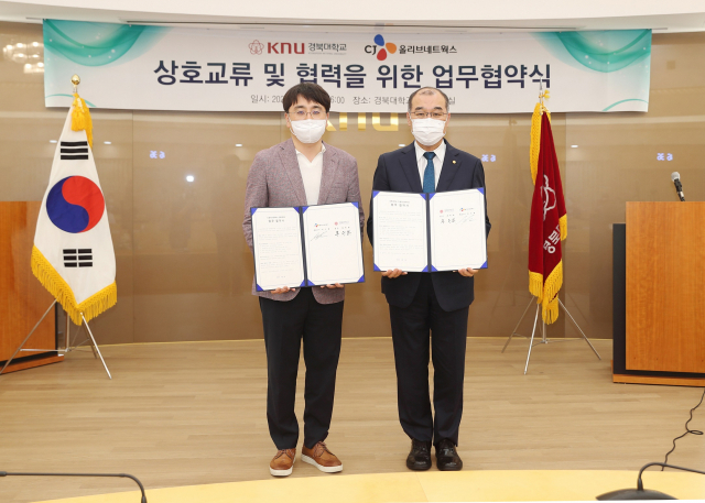 홍원화(오른쪽) 경북대 총장과 차인혁 CJ올리브네트웍스 대표이사가 협약서를 들어보이고 있다. 경북대 제공