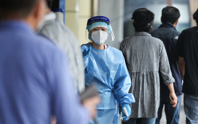 7일 오전 서울 송파구 송파구보건소 선별진료소에서 관계자가 시민들에게 검사 안내를 하고 있다. 이날 보건 당국이 발표한 코로나19 신규 확진자는 1천597명으로 월요일 기준 최다를 기록했다. 연합뉴스